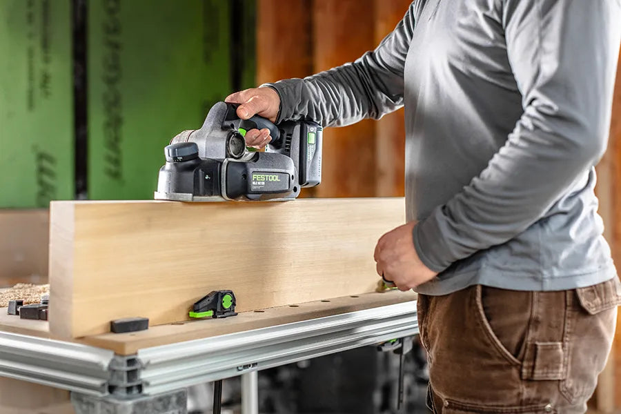 Person using a Festool - HLC 82 Cordless Planer on a board of wood